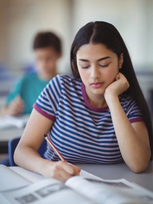 attentive-schoolgirl-studying-classroom